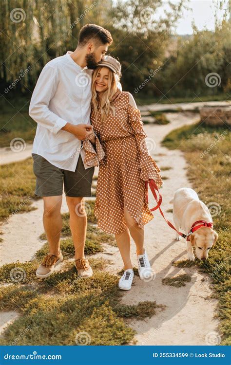 Guy in Light Shirt and Khaki Shorts Kisses His Beloved Wife, Holding ...