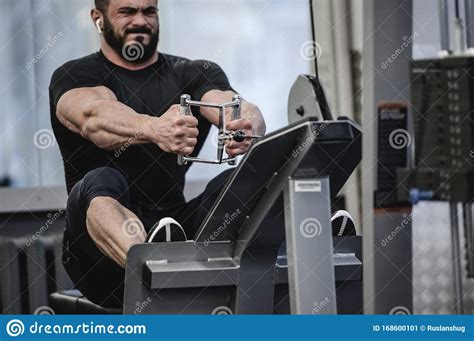 Strong Young Man With Beard In Black Sportswear Pulling Heavy Weight ...