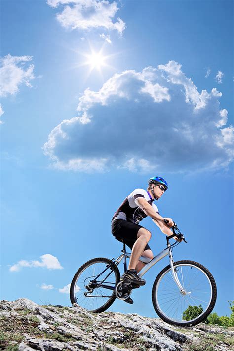 黄昏下奋力向上坡骑行的自行车运动员图片免费下载_红动网