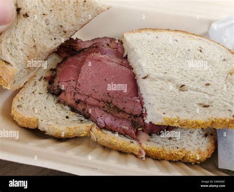 Close-up of pastrami sandwich on rye bread in takeout container at Wise ...