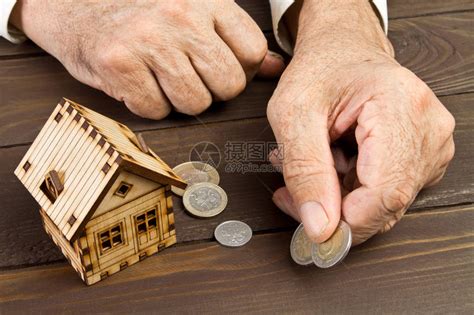 老年人手和有硬币的模范家庭按揭和银行贷款的概念高清图片下载-正版图片502815113-摄图网