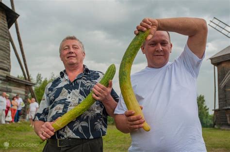 Persona disfrazada de pepino gigante en un mercado.