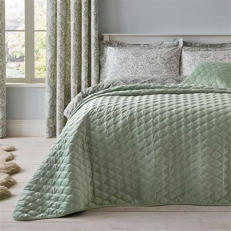 This bedspread features a quilted geometric design on velvet in a green ...