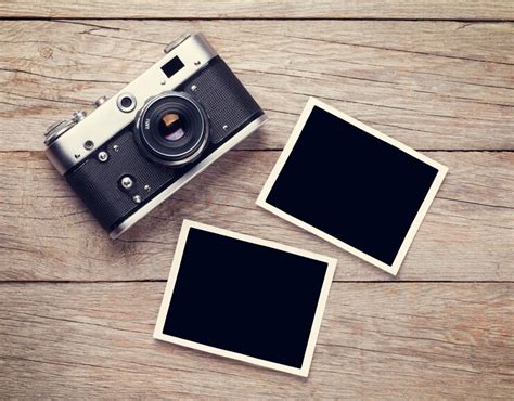 Vintage film camera and two blank photo frames on wooden table. top ...