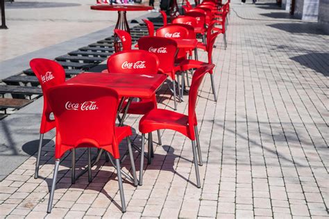 plastic red chairs and tables with advertising logo of Coca-Cola brand ...