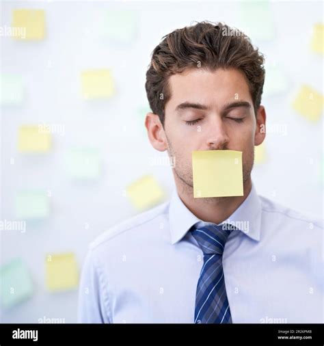 I had to sign a confidentiality agreement. a young office worker with a sticky note stuck over ...