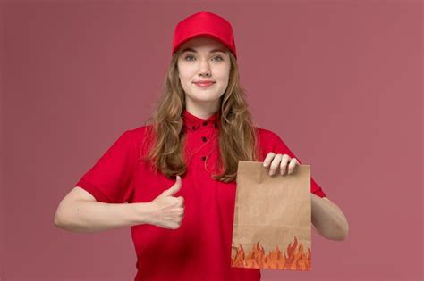 Mensageira de uniforme vermelho segurando um pacote de papel de comida ...