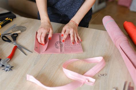 修指甲的手工艺妇女在家里做粉红色皮革手工钱包高清图片下载-正版图片505239411-摄图网