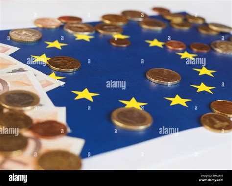 Euro banknotes and coins (EUR), currency of European Union over flag of Europe Stock Photo - Alamy