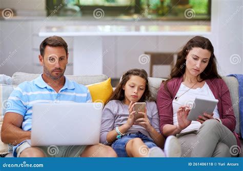 Connecting As a Family. a Family Sitting on the Sofa and Using Their ...