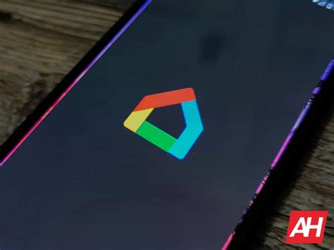 A phone displaying a Google logo is held up to a screen displaying a Wiz logo