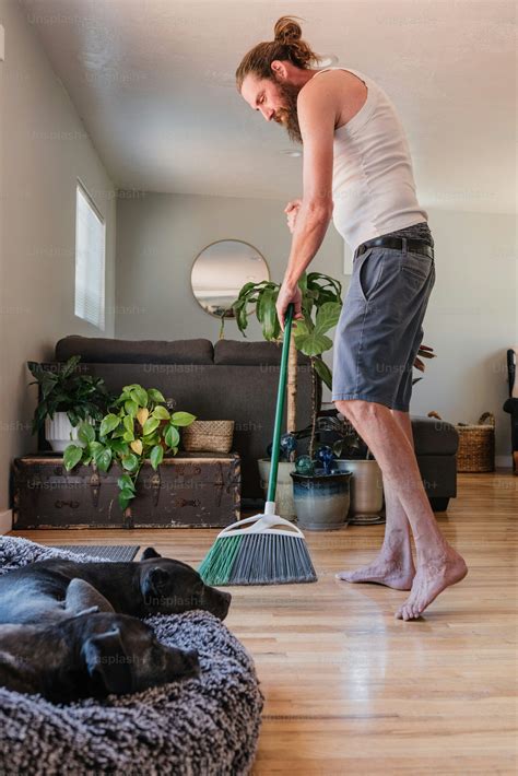 A woman sweeping the floor with a broom photo – Household chores Image ...