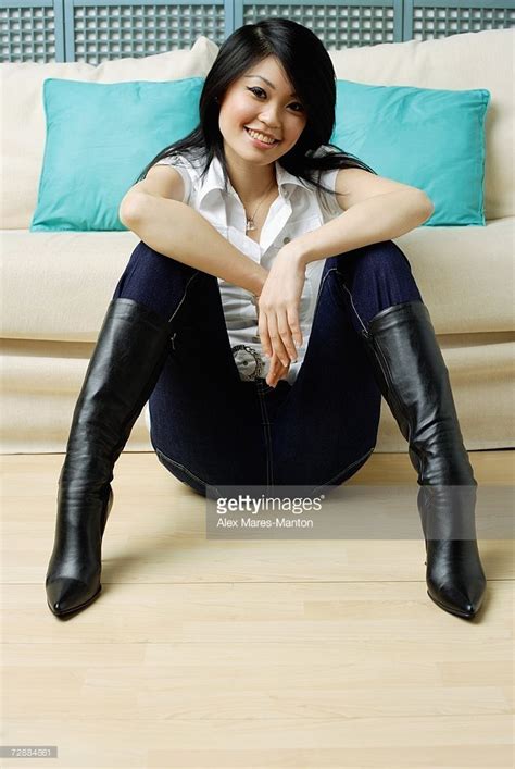 Stock Photo : Young woman sitting on floor, legs apart, hands on knees ...