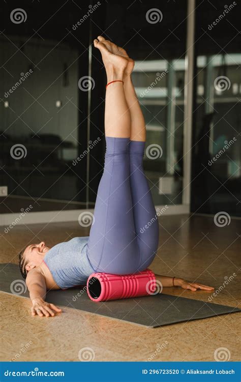 Slender Girl Doing Yoga with a Big Massage Roller on the Floor Stock ...
