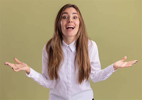 Surprised young pretty caucasian girl holds hands open on olive green ...
