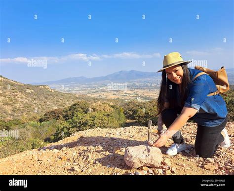 Latina woman with hat and miner's pick hammer works as a geologist ...