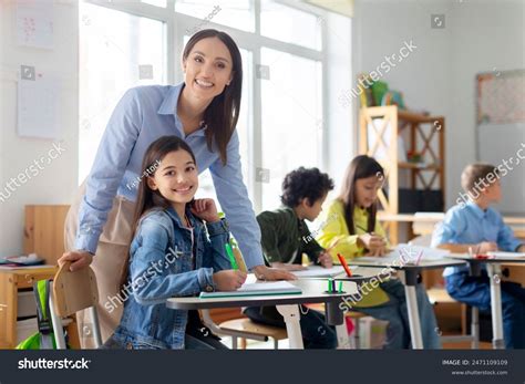 Стоковая фотография 2471109109: Cheerful Young Female Teacher Working ...
