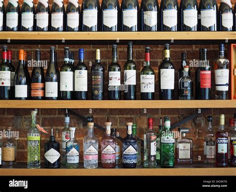 Bottles of alcoholic drinks lined up on a shelf behind a bar Stock ...