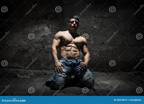 Muscular Shirtless Young Man on His Knees with Light Above Head Stock ...