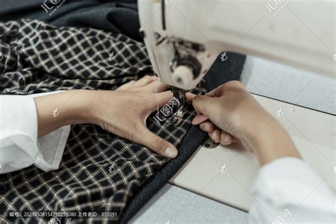 在缝纫机站工作的妇女把针放进布里的手。,摄影素材,汇图网www.huitu.com