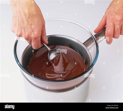 Dessert spoon stirs melting dark chocolate Stock Photo - Alamy
