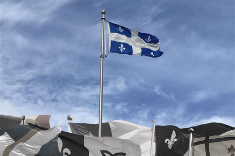 A Quebec flag in colour stands over numerous other French-Canadian ...