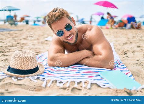 Handsome Fitness Caucasian Man at the Beach on a Sunny Day Sunbathing ...