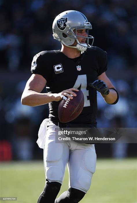 Derek Carr of the Oakland Raiders rolls out to pass against the... News ...