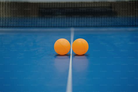 A ping pong paddle and an orange on a blue ping pong table photo – Sport Image on Unsplash