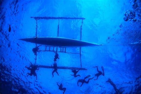 Pessoa em um barco com outra pessoa praticando snorkel ao lado do barco