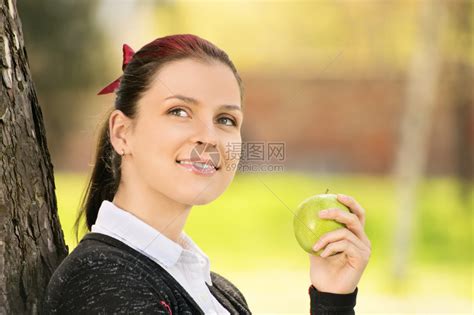 美丽的微笑的年轻女孩拿着苹果高清图片下载-正版图片507537497-摄图网