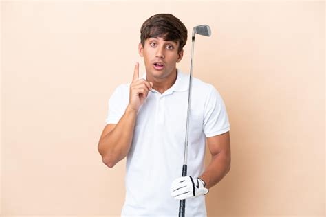 Young golfer player man isolated on ocher background intending to ...