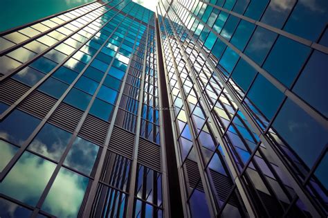 现代化建筑形式下摩天大厦外玻璃表面干净透明倒映着蓝天白云