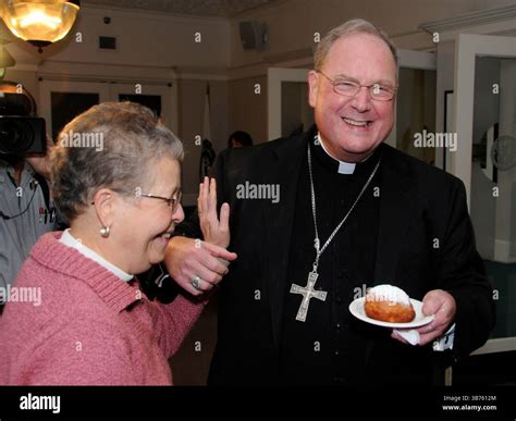 Archbishop Timothy Dolan, with paczki in hand, is greeted by Sr ...