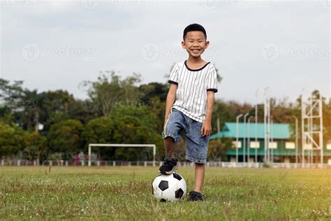 Asian boy stepping on a ball while kicking soccer on the field. soft ...