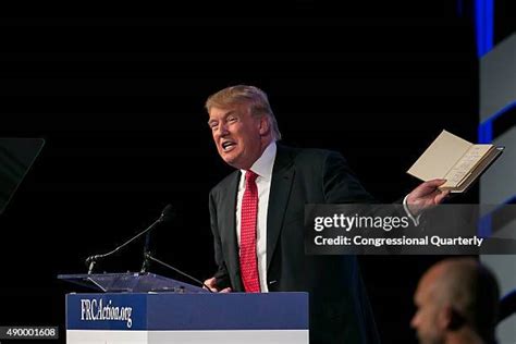 Trump, with his family watching, raises his right hand and places his left hand on the Bible as he t