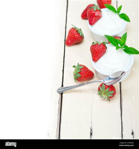 Organic Greek yogurt and strawberry over white rustic wood table Stock ...