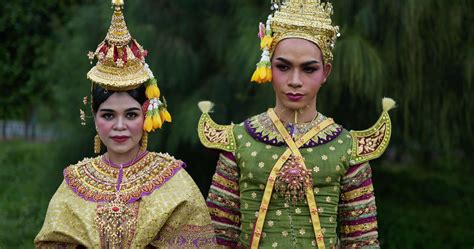Portrait of Thai woman and man in traditional dress looking at camera ...
