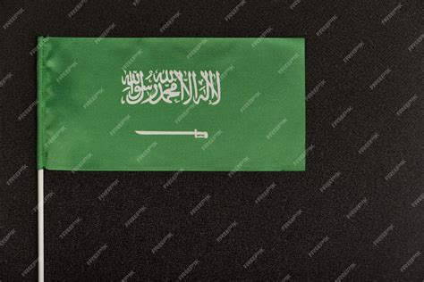Premium Photo | Table flag of kingdom of saudi arabia on black background. green flag with sword.