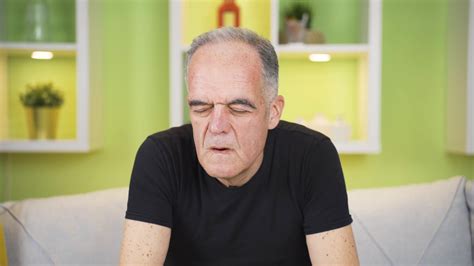 Sweating problem. Fever and sweating. Sweating old man gives air to his ...