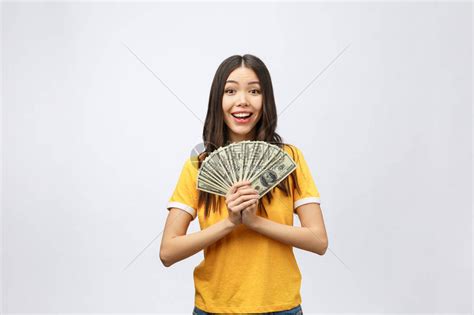 拿着银行钞票的女人显示现金的相当年轻的模型白色背景下华丽的多民族亚洲和高加索高清图片下载-正版图片503097308-摄图网