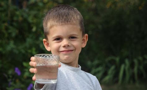 Child drinks water selective focus | Premium Photo