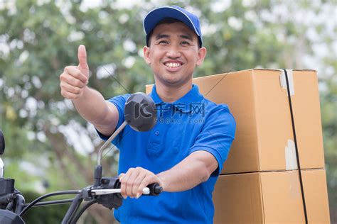 送货员发送订单包裹与电机和拇指向上高清摄影大图-千库网