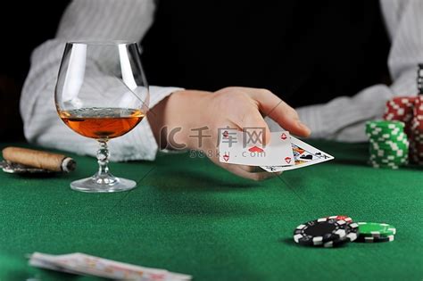男人坐在赌桌旁打牌高清摄影大图-千库网