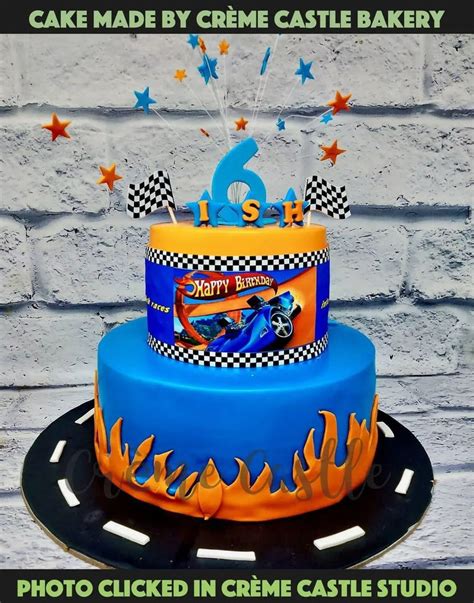 A Hot Wheels theme cake in blue color and two tiers with Hot wheel car ...