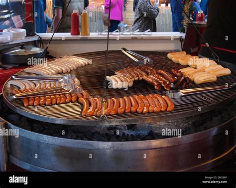 German sausages being cooked on commercial charcoal grill, Devon, UK ...