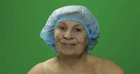 戴保护帽的老年女微笑着寻找照相机整容手术绿高清图片下载-正版图片506088195-摄图网