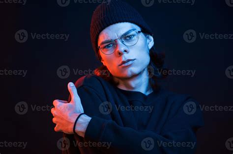 Calm and quiet. Studio shot in dark studio with neon light. Portrait of ...