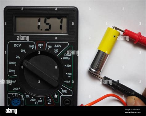 Voltage testing of AA type cell battery with a voltmeter Stock Photo ...