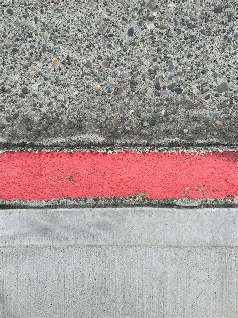 Painted red curb along urban sidewalk and street - Stock Image - Everypixel